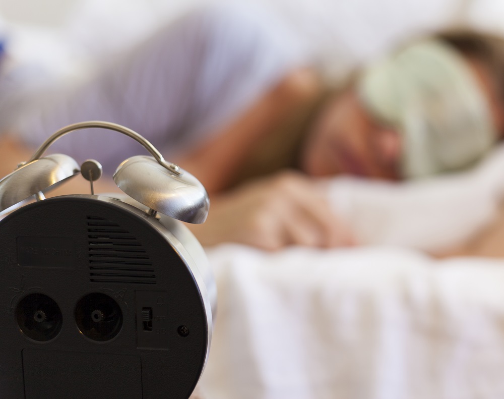 girl-sleeping-alarm-clock-in-foreground
