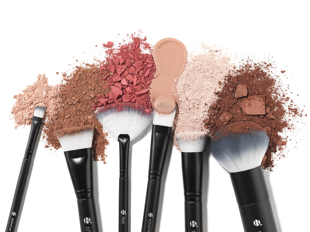 set of makeup brushes with colourful swatches of makeup powders