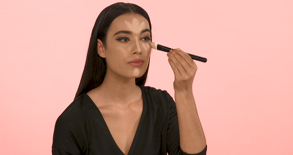 Woman applying light cream contour to face