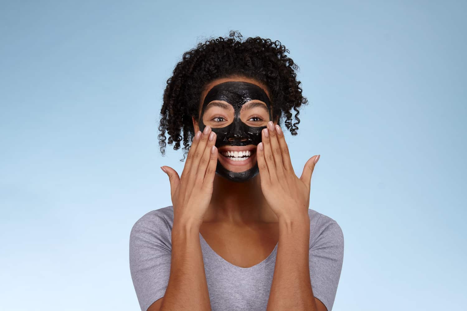 happy lady wearing a charcoal face mask smiling