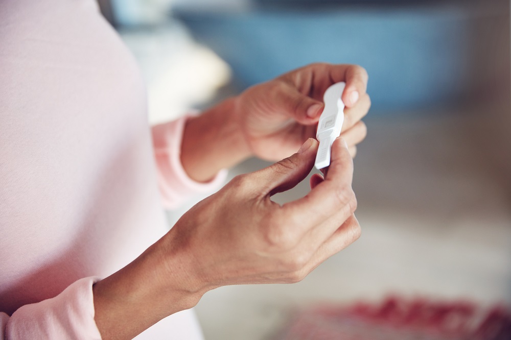 Woman holding an at-home pregnancy test