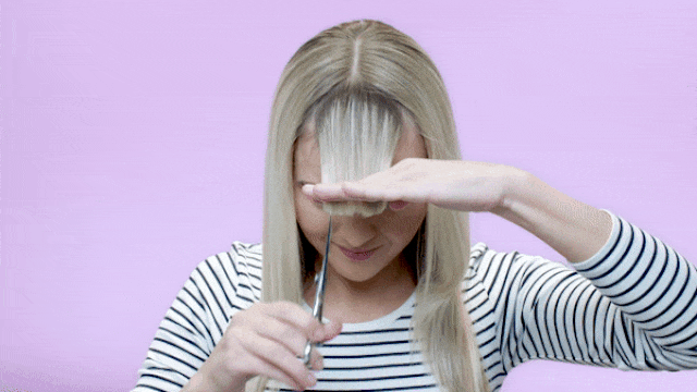 woman trimming her fringe with scissors