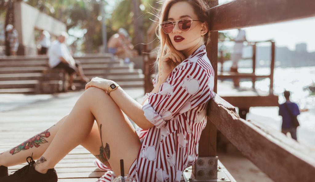 Girl with tattoos sitting in the sun