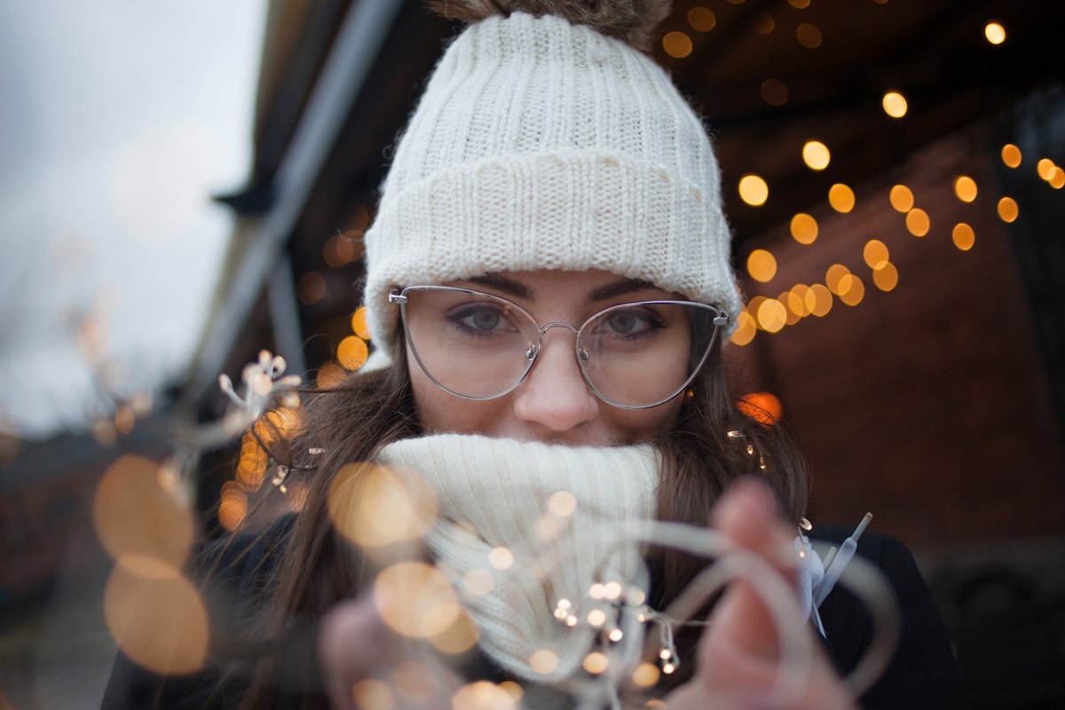 Young beautiful woman with coffee Cup outdoors. Magic lights