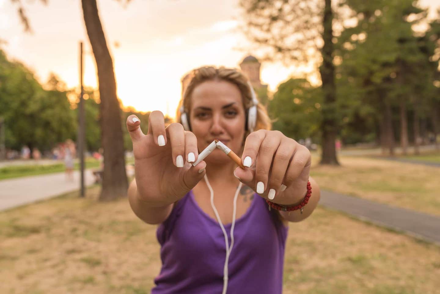 Young beautiful woman holding broken cigarette