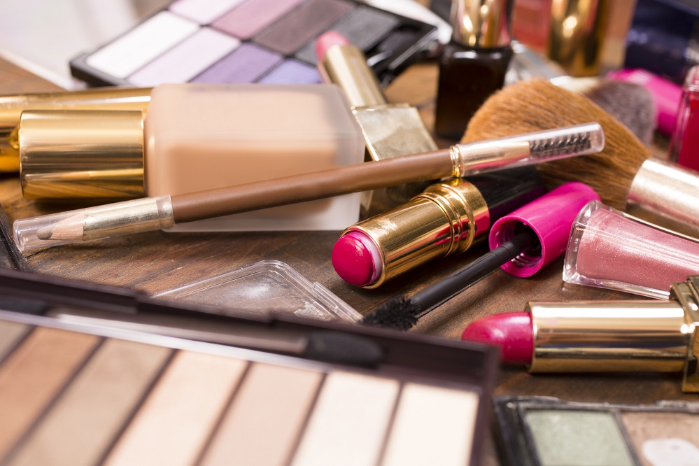 Used makeup products lie on messy dressing table