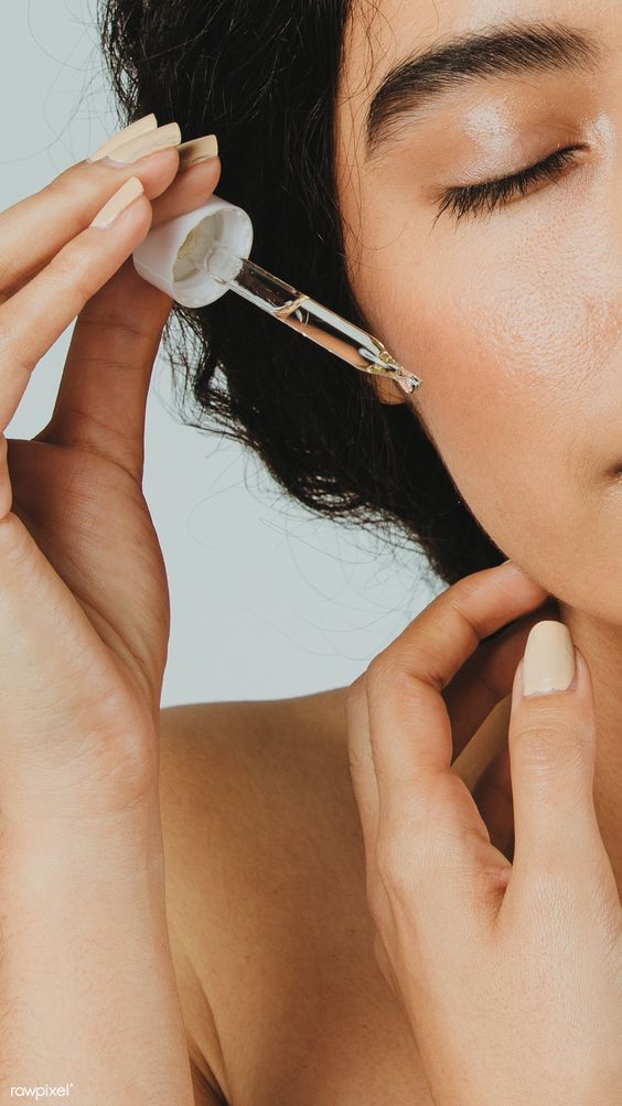 Woman applying serum to cheek