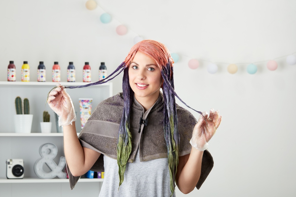 young woman with different coloured dye applied to all parts of her hair 
