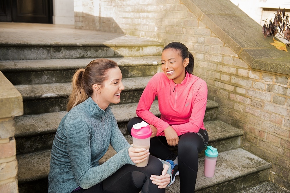 2 Young women chatting on staircase after a workout