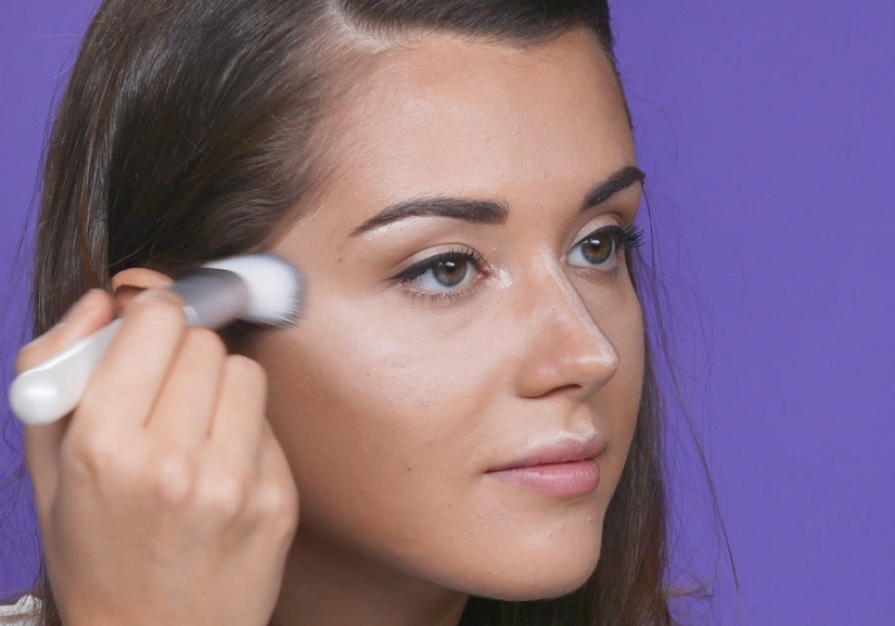 Woman adding highlighter to face
